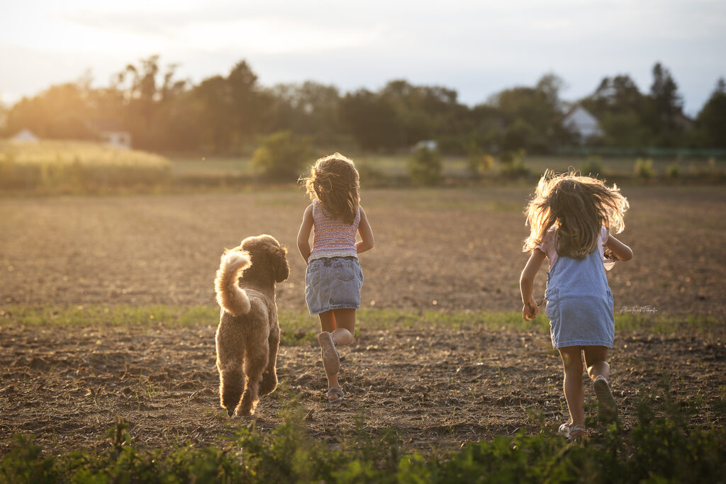Ally läuft mit Kindern auf einem Feld.